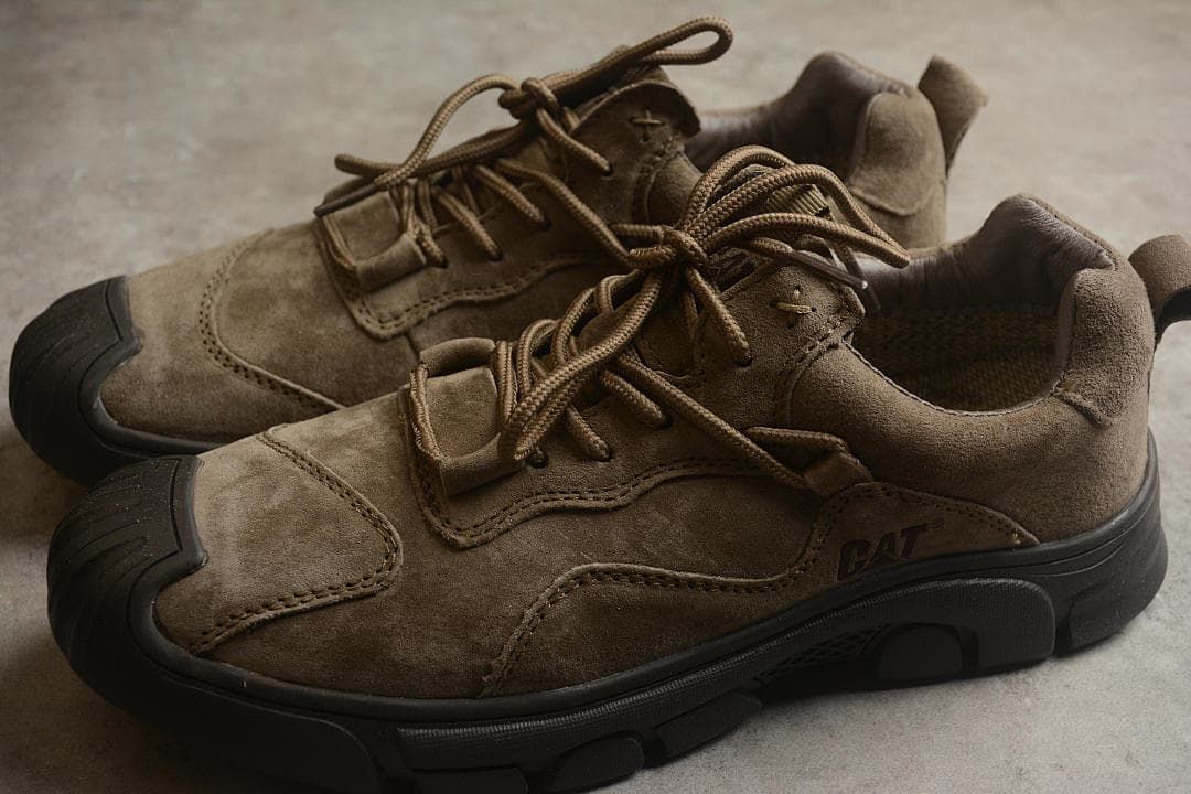 Pair of brown low-top CAT shoes shown from an angled top view.